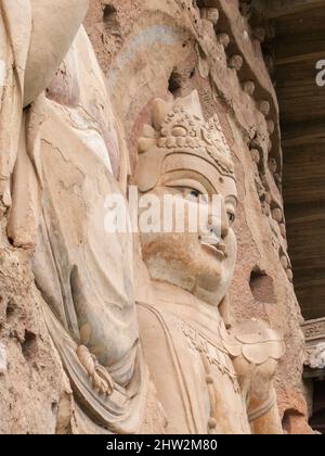 Buddha stellt Darstellungen und buddhistische Bilder dar (die erst vor kurzem mit Beton restauriert wurden) auf der Felswand der Maijishan-Grotten, die früher als Maichishan romanisiert wurden, eine Serie von 194 Höhlen, die an der Seite des Hügels von Majishan in Tianshui, Provinz Gansu, China, geschnitten wurden. Treppen und Gehwege sind an der schieren Felswand angebracht, um den Besuchern einen engen Kontakt mit den Tonfiguren und alten Steinschnitzereien an der Stelle zu ermöglichen. (67/125) Stockfoto
