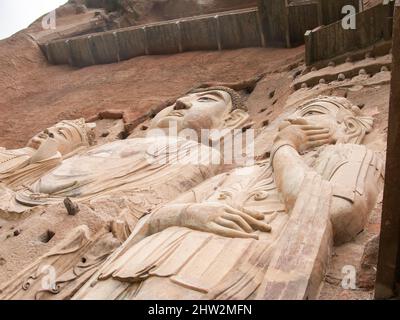 Buddha stellt Darstellungen von Darstellungen und buddhistischen Bildern dar (die erst vor kurzem mit neuen Materialien restauriert worden zu sein scheinen) auf der Felswand der Maijishan-Grotten, die früher als Maichishan romanisiert wurden, Dies sind eine Reihe von 194 Höhlen, die an der Seite des Hügels von Majishan in Tianshui, Provinz Gansu, China, geschnitten wurden. Treppen und Gehwege sind an der schieren Felswand angebracht, um den Besuchern einen engen Kontakt mit den Tonfiguren und alten Steinschnitzereien an der Stelle zu ermöglichen. (67/125) Stockfoto