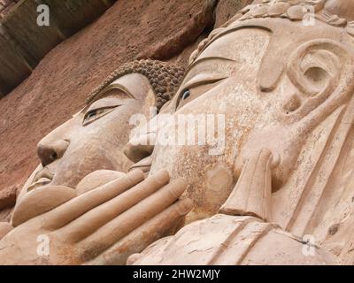 Buddha stellt Darstellungen von Darstellungen und buddhistischen Bildern dar (die erst vor kurzem mit neuen Materialien restauriert worden zu sein scheinen) auf der Felswand der Maijishan-Grotten, die früher als Maichishan romanisiert wurden, Dies sind eine Reihe von 194 Höhlen, die an der Seite des Hügels von Majishan in Tianshui, Provinz Gansu, China, geschnitten wurden. Treppen und Gehwege sind an der schieren Felswand angebracht, um den Besuchern einen engen Kontakt mit den Tonfiguren und alten Steinschnitzereien an der Stelle zu ermöglichen. (67/125) Stockfoto