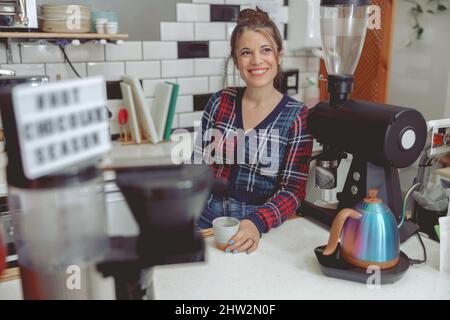 Porträt einer glücklichen Barista, die Gäste bedient Stockfoto