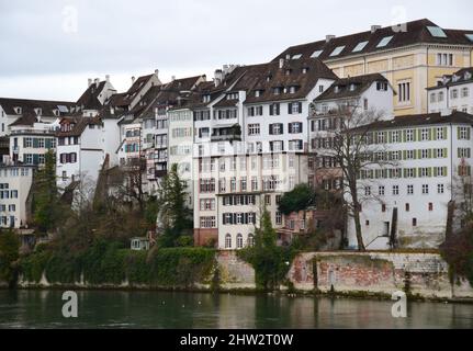 Alte Gebäude am Flussufer bei Sonnenuntergang in Basel, Schweiz Stockfoto