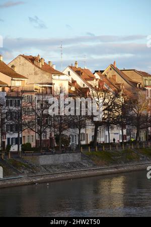 Alte Gebäude am Flussufer bei Sonnenuntergang in Basel, Schweiz Stockfoto