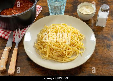 Gericht mit Spaghetti mit einem Topf Bolognese-Sauce auf einem Tisch Stockfoto