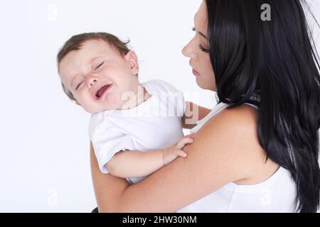 Babys sind harte Arbeit. Eine Mutter hält ihren weinenden Jungen in der Hand. Stockfoto