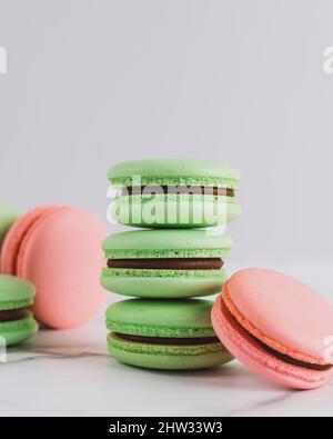 Nahaufnahme von grünen und rosa Macarons auf weißem Hintergrund Stockfoto