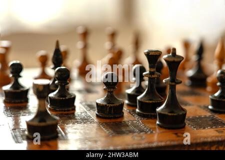 Bauer mit anderen Figuren auf dem alten Schachbrett. Stockfoto