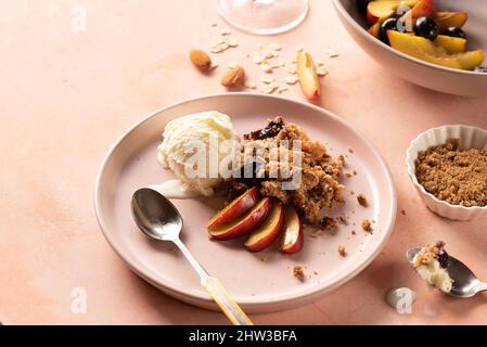 Glutenfreier Pfirsich zum Frühstück oder Dessert mit frischer Pfirsichmandel 4, Hafer und Eiscreme garniert Stockfoto