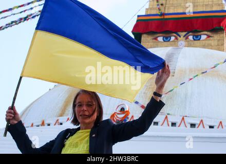 Kathmandu, Nepal. 03. März 2022. Vor Boudhanath Stupa, einem UNESCO-Weltkulturerbe, schwenkt ein ausländischer Delegierter die ukrainische Flagge während einer Mahnwache mit Butterlampen, um die russische Invasion in der Ukraine zu beenden und für den Weltfrieden in Kathmandu, Nepal, zu stehen. (Foto: Abhishek Maharjan/Sipa USA) Quelle: SIPA USA/Alamy Live News Stockfoto