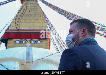 Kathmandu, Nepal. 03. März 2022. Der ausländische Delegierte steht vor Boudhanath Stupa, einem UNESCO-Weltkulturerbe, während einer Mahnwache mit Butterlampen, um die russische Invasion in der Ukraine zu beenden und für den Weltfrieden in Kathmandu, Nepal, zu stehen. (Foto: Abhishek Maharjan/Sipa USA) Quelle: SIPA USA/Alamy Live News Stockfoto