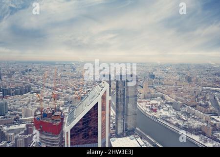 Skyline der Stadt im Hintergrund. Luftaufnahme der Moskauer Hauptstadt von Russland. Von oben, Blick auf die Stadt mit blauem Himmel. Panorama der Moskauer Stadtlandschaft. Stockfoto