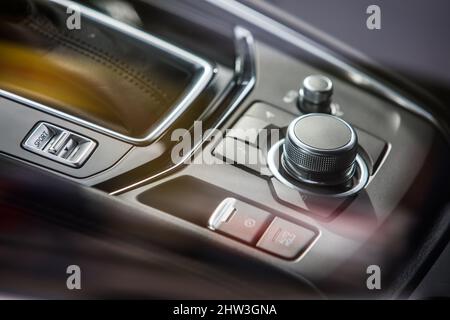 Nahaufnahme der modernen Mittelkonsole mit Tasten auf der Fahrzeugkonsole. Stockfoto