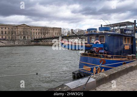 La seine avec des bateaux, sous le Pont des Arts à Paris, Frankreich, avec le Louvre au loin Stockfoto