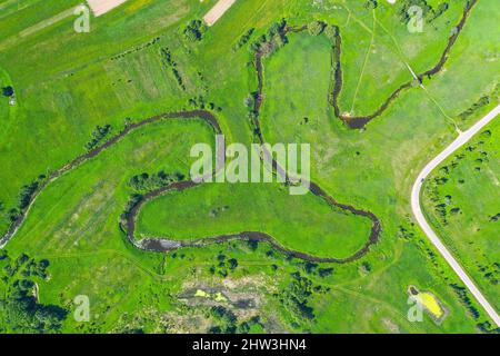 Luftlandschaft Landschaft von gewundenen kleinen Fluss, Bach im grünen Feld, Draufsicht Wiese Stockfoto