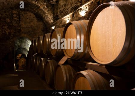 Mittelalterliche unterirdische Weinkeller mit alten Rotweinfässern für den Ausbau von vino nobile di Montepulciano in der Altstadt auf dem Hügel Montepulciano in der Toskana, Es Stockfoto