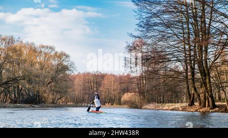 MINSK, WEISSRUSSLAND - 03. März 2022: Ein einflügiger Paddler segelt im Frühjahr mit einem Kanu den Fluss hinunter Stockfoto