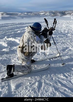 Ein Green Beret, der der 10. Special Forces Group (Airborne) zugewiesen wurde, führt während des Pre-Deployment Trainings für ARCTIC EDGE 22 im Yukon Training Area, Alaska, am 19. Februar 2022 eine Reaktion auf Kontaktkampfübung durch. ARCTIC EDGE 22, 28. Februar bis 17. März, ist eine alle zwei Jahre geplante Übung des US Northern Command (USNORTHCOM), die die Teilnehmer an den besten Trainingsstandorten in ganz Alaska realistisch und effektiv ausbilden soll. (DoD-Foto) Stockfoto