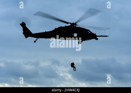 Am 2. März 2022 stößt ein dem Rettungsgeschwader 57. zugeordneter Pararescueman von einem HH-60G Pave Hawk in Rumänien ab.die 56. RQS und die 57. RQS, die beide dem 31. Fighter Wing, der Aviano Air Base, Italien, zugewiesen wurden, Stellen Such- und Rettungskapazitäten für das NATO-Bündnis bereit und führen gleichzeitig gemeinsame Trainingsmissionen mit der rumänischen Luftwaffe durch. Beide sind in der Lage, bei Tag und Nacht Allwettermissionen in Operationssälen weltweit durchzuführen Luftwaffe Foto von Senior Airman Noah Sudolcan) Stockfoto