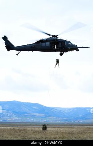 Am 2. März 2022 stößt ein dem Rettungsgeschwader 57. zugeordneter Pararescueman von einem HH-60G Pave Hawk in Rumänien ab.die 56. RQS und die 57. RQS, die beide dem 31. Fighter Wing, der Aviano Air Base, Italien, zugewiesen wurden, Stellen Such- und Rettungskapazitäten für das NATO-Bündnis bereit und führen gleichzeitig gemeinsame Trainingsmissionen mit der rumänischen Luftwaffe durch. Beide sind in der Lage, bei Tag und Nacht Allwettermissionen in Operationssälen weltweit durchzuführen Luftwaffe Foto von Senior Airman Noah Sudolcan) Stockfoto