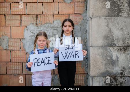 Kinder halten Plakate mit schriftlichen STOPP GEWALT und FRIEDEN zur Unterstützung des Friedens. Konzept des 'No war' in der Ukraine und in der Welt. Russischer Konflikt Stockfoto