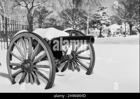 An einem Wintertag in einem öffentlichen Park liegt ein Vintage-Kanon mit Schnee bedeckt Stockfoto