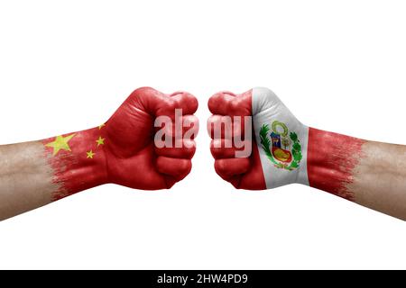 Zwei Hände schlagen sich gegenseitig auf weißem Hintergrund zu. Länderflaggen bemalten Fäuste, Konfliktkrisenkonzept zwischen china und peru Stockfoto