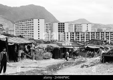 Das Leben im Jahr 1960s das koloniale Hongkong mit einer rapide wachsenden Bevölkerung von mehr als 4 Millionen Menschen, viele sind gezwungen, in Besetzerhütten und Kleinstädten zu leben, aufgenommen im Januar 1968. Unser Bild zeigt ... Shanty Stadt mit neuen Hochhäusern Umsiedlungsblöcke im Hintergrund. Stockfoto