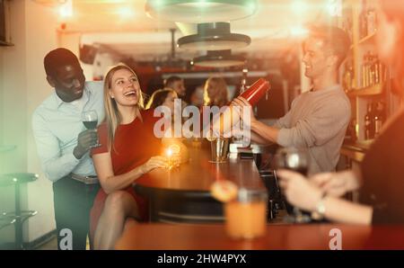 Paare trinken Cocktails und haben Spaß im Nachtclub Stockfoto