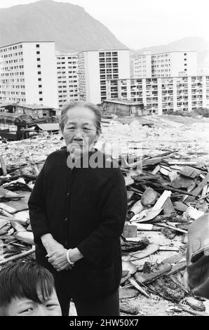 Das Leben im Jahr 1960s das koloniale Hongkong mit einer rapide wachsenden Bevölkerung von mehr als 4 Millionen Menschen, viele sind gezwungen, in Besetzerhütten und Kleinstädten zu leben, aufgenommen im Januar 1968. Unser Bild zeigt ... ältere Frau in einer Kleinstadt mit Umsiedlungsblöcken im Hintergrund. Stockfoto