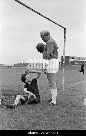 David Bradley (14 Jahre) spielt die Rolle von Billy Casper, abgebildet mit seinem Kestral, auf dem Filmset des Films kes. Hier spielt Billy Casper den Torwart in der Schulfußballspielszene. Mit ihm ist Herr Sugden, gespielt von Brian Glover. Mr. Sugden glaubt, dass er Bobby Charlton ist, der ein Manchester United Shirt trägt und seine Spieler auf dem Spielfeld anordnet. Kes ist ein 1969 veröffentlichter Dramaturgie unter der Regie von Ken Loach und produziert von Tony Garnett. Der Film basiert auf dem Roman A Kestrel for a Knave aus dem Jahr 1968, der vom in Barsley geborenen Autor Barry Hines geschrieben wurde. Der Film belegt den siebten Platz im Briti Stockfoto