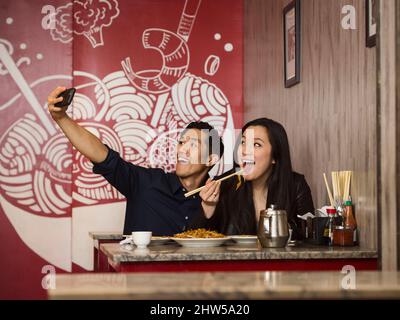 Chinesisches Paar posieren für Handy Selfie im restaurant Stockfoto