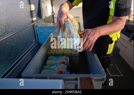 Kelsterbach, Deutschland. 03. März 2022. Ein Mitarbeiter packt Windeln in einen großvolumigen Krankenwagen des Rettungsdienstes „Veritas Ambulance“, der an eine ukrainische Hilfsorganisation an der polnisch-ukrainischen Grenze übergeben wird. (Zu dpa „jeder will der Ukraine helfen – aber welche Hilfe ist nachhaltig?“) Quelle: Sebastian Gollnow/dpa/Alamy Live News Stockfoto