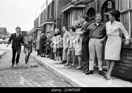 Eine neue Straßeneinstellung für die „Coronation Street“. Granada TV hat ein Outdoor-Set für einige der Szenen gebaut. Im Bild sind die Darsteller Dennis Tanner (Philip Lowrie) mit seiner Braut Jenny Sutton (Mitzi Rogers) nach ihrer Hochzeit mit Annie Walker (Doris Speed), Ena Sharples (Violet Carson), Emily Nugent (Eileen Derbyshire), Valerie Barlow (Anne Reid), Ken Barlow (William Roache) Len Fairclough (Peter Adamson) und Elsie Tanner (Pat Phoenix). 18. Mai 1968. Stockfoto