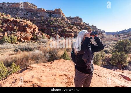 USA, Utah, Escalante, Senior Wanderer beim Blick durch das Fernglas Stockfoto