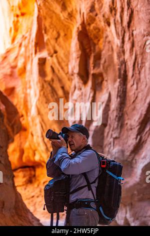 USA, Utah, Escalante, Senior Wanderer, der Felsformationen im Kodachrome Basin State Park in der Nähe des Escalante Grand Staircase National Monument erkundet und fotografiert Stockfoto