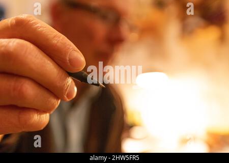 Nahaufnahme des mans-Hand-Haltestifts Stockfoto