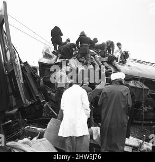 Ein Arzt wartet auf Feuerwehrleute, um die Opfer von den Trümmern der Eisenbahnkatastrophe von Hixon zu befreien. Der Unfall ereignete sich am Samstag (6-1-68), nachdem ein InterCity-Zug auf dem Bahnübergang in Hixon in der Nähe von Stafford mit einem riesigen Transformator zusammenstürzte. Bei dem Unfall wurden elf Menschen getötet und vierzig verletzt. 6.. Januar 1968 Stockfoto