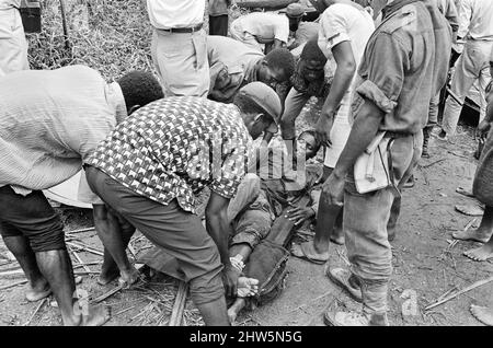 Biafranische Soldaten und Helfer sahen hier, wie sie während des Biafra-Konflikts einen verletzten Kameraden auf eine Bahre trugen. 11.. Juni 1968. Der nigeranische Bürgerkrieg, auch bekannt als Biafrankrieg, dauerte zweieinhalb Jahre, vom 6. Juli 1967 bis zum 15. Januar 1970, und wurde gekämpft, um der Abspaltung von Biafra von Nigeria entgegenzuwirken. Die indigenen Igbo-Bewohner von Biafra fühlten sich nach der Unabhängigkeit von Großbritannien nicht mehr mit der nordeuropäischen Bundesregierung koexistieren können. Politische, wirtschaftliche, ethnische, kulturelle und religiöse Spannungen kochten schließlich nach den 1966 Millionen in einen Bürgerkrieg über Stockfoto