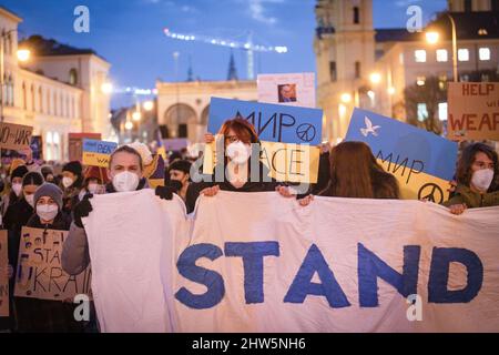 München, Deutschland. 03. März 2022. Am 3.. März versammelten sich 2022 2.000 Menschen auf dem Odeonsplatz in München, um gegen die russische Invasion in der Ukraine zu protestieren und ihre Solidarität mit dem ukrainischen Volk zu zeigen. Die Kundgebung wurde von Fridays für das zukünftige München organisiert. Banner mit der Aufschrift: „Stand with Ukraine“ (Foto: Alexander Pohl/Sipa USA) Quelle: SIPA USA/Alamy Live News Stockfoto