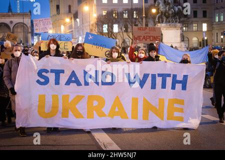 München, Deutschland. 03. März 2022. Am 3.. März versammelten sich 2022 2.000 Menschen auf dem Odeonsplatz in München, um gegen die russische Invasion in der Ukraine zu protestieren und ihre Solidarität mit dem ukrainischen Volk zu zeigen. Die Kundgebung wurde von Fridays für das zukünftige München organisiert. Banner mit der Aufschrift: „Stand with Ukraine“ (Foto: Alexander Pohl/Sipa USA) Quelle: SIPA USA/Alamy Live News Stockfoto