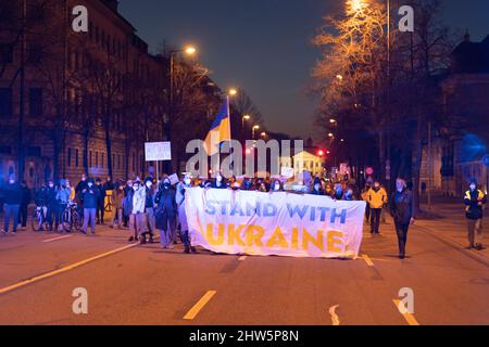 München, Deutschland. 03. März 2022. Am 3.. März versammelten sich 2022 2.000 Menschen auf dem Odeonsplatz in München, um gegen die russische Invasion in der Ukraine zu protestieren und ihre Solidarität mit dem ukrainischen Volk zu zeigen. Die Kundgebung wurde von Fridays für das zukünftige München organisiert. Banner mit der Aufschrift: „Stand with Ukraine“ (Foto: Alexander Pohl/Sipa USA) Quelle: SIPA USA/Alamy Live News Stockfoto