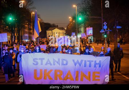 München, Deutschland. 03. März 2022. Am 3.. März versammelten sich 2022 2.000 Menschen auf dem Odeonsplatz in München, um gegen die russische Invasion in der Ukraine zu protestieren und ihre Solidarität mit dem ukrainischen Volk zu zeigen. Die Kundgebung wurde von Fridays für das zukünftige München organisiert. Banner mit der Aufschrift: „Stand with Ukraine“ (Foto: Alexander Pohl/Sipa USA) Quelle: SIPA USA/Alamy Live News Stockfoto