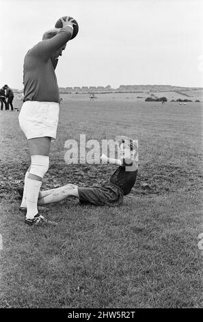 David Bradley (14 Jahre) spielt die Rolle von Billy Casper, abgebildet mit seinem Kestral, auf dem Filmset des Films kes. Hier spielt Billy Casper den Torwart in der Schulfußballspielszene. Mit ihm ist Herr Sugden, gespielt von Brian Glover. Mr. Sugden glaubt, dass er Bobby Charlton ist, der ein Manchester United Shirt trägt und seine Spieler auf dem Spielfeld anordnet. Kes ist ein 1969 veröffentlichter Dramaturgie unter der Regie von Ken Loach und produziert von Tony Garnett. Der Film basiert auf dem Roman A Kestrel for a Knave aus dem Jahr 1968, der vom in Barsley geborenen Autor Barry Hines geschrieben wurde. Der Film belegt den siebten Platz im Briti Stockfoto