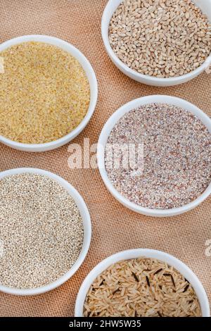 Auswahl verschiedener und alternativer gesunder Körner auf hessischer Oberfläche Stockfoto