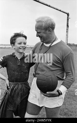 David Bradley (14 Jahre) spielt die Rolle von Billy Casper, abgebildet mit seinem Kestral, auf dem Filmset des Films kes. Hier spielt Billy Casper den Torwart in der Schulfußballspielszene. Mit ihm ist Herr Sugden, gespielt von Brian Glover. Mr. Sugden glaubt, dass er Bobby Charlton ist, der ein Manchester United Shirt trägt und seine Spieler auf dem Spielfeld anordnet. Kes ist ein 1969 veröffentlichter Dramaturgie unter der Regie von Ken Loach und produziert von Tony Garnett. Der Film basiert auf dem Roman A Kestrel for a Knave aus dem Jahr 1968, der vom in Barsley geborenen Autor Barry Hines geschrieben wurde. Der Film belegt den siebten Platz im Briti Stockfoto