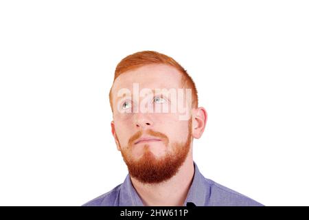 Denken Sie an etwas Gutes. Porträt eines Rotschopf-Mannes mit Gesichtsausdruck isoliert auf weißem Hintergrund. Stockfoto