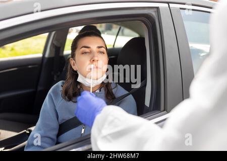 Mitarbeiter im Gesundheitswesen, die Coronavirus-Tests im Auto durchführen Stockfoto
