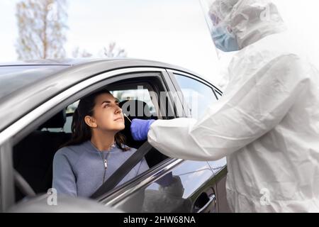 Mitarbeiter im Gesundheitswesen, die Coronavirus-Tests im Auto durchführen Stockfoto