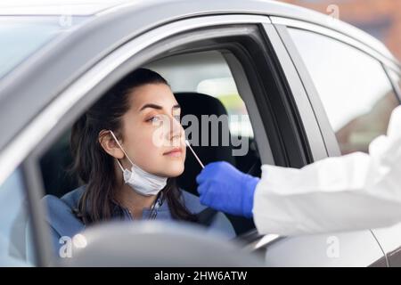Mitarbeiter im Gesundheitswesen, die Coronavirus-Tests im Auto durchführen Stockfoto