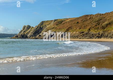 Blick nach Westen auf die Klippen und Great Tor auf Three Cliffs Bay an einem sonnigen Februartag auf Gower Stockfoto