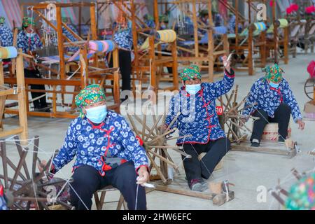 YONGJI, CHINA - 4. MÄRZ 2022 - Textilkünstler arbeiten in einer Weberei-Werkstatt in der Stadt Yongji, der nordchinesischen Provinz Shanxi, 4. März 2022. Stockfoto